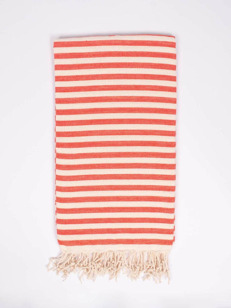 Folded striped orange and cream towel, with cream colored tassels